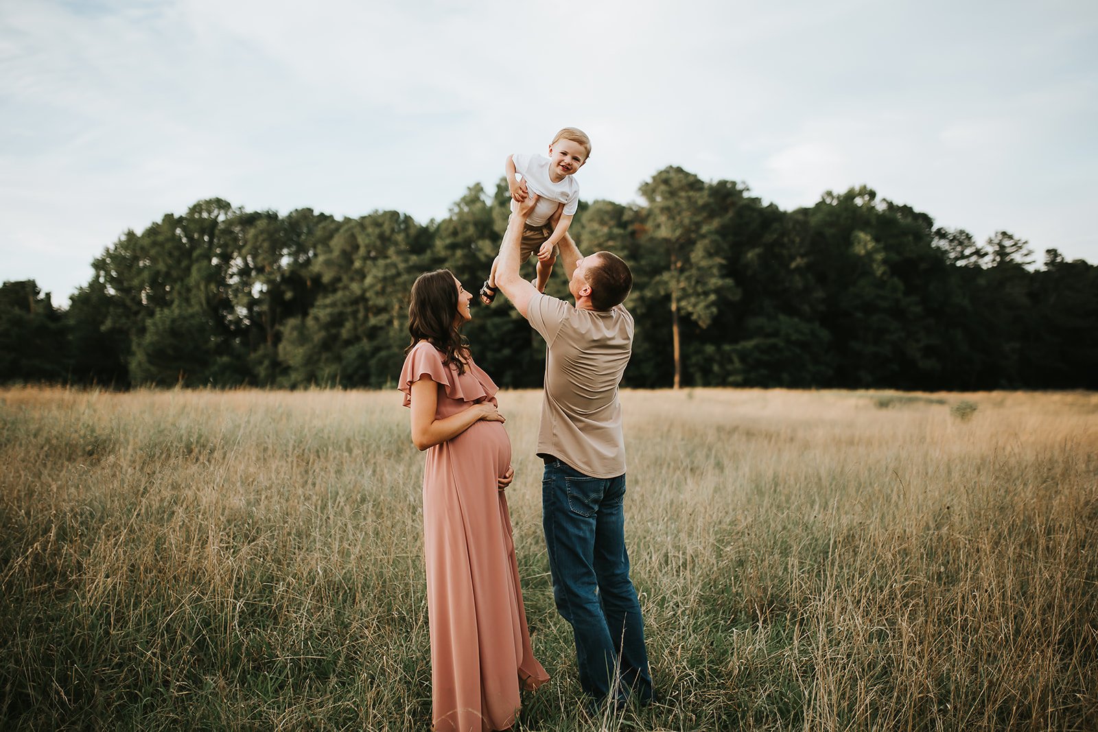 Maternity photo at Little Mulberry Park in Gwinnett County GA with a pregnant mom watching her husband and son play during a family photography session.
