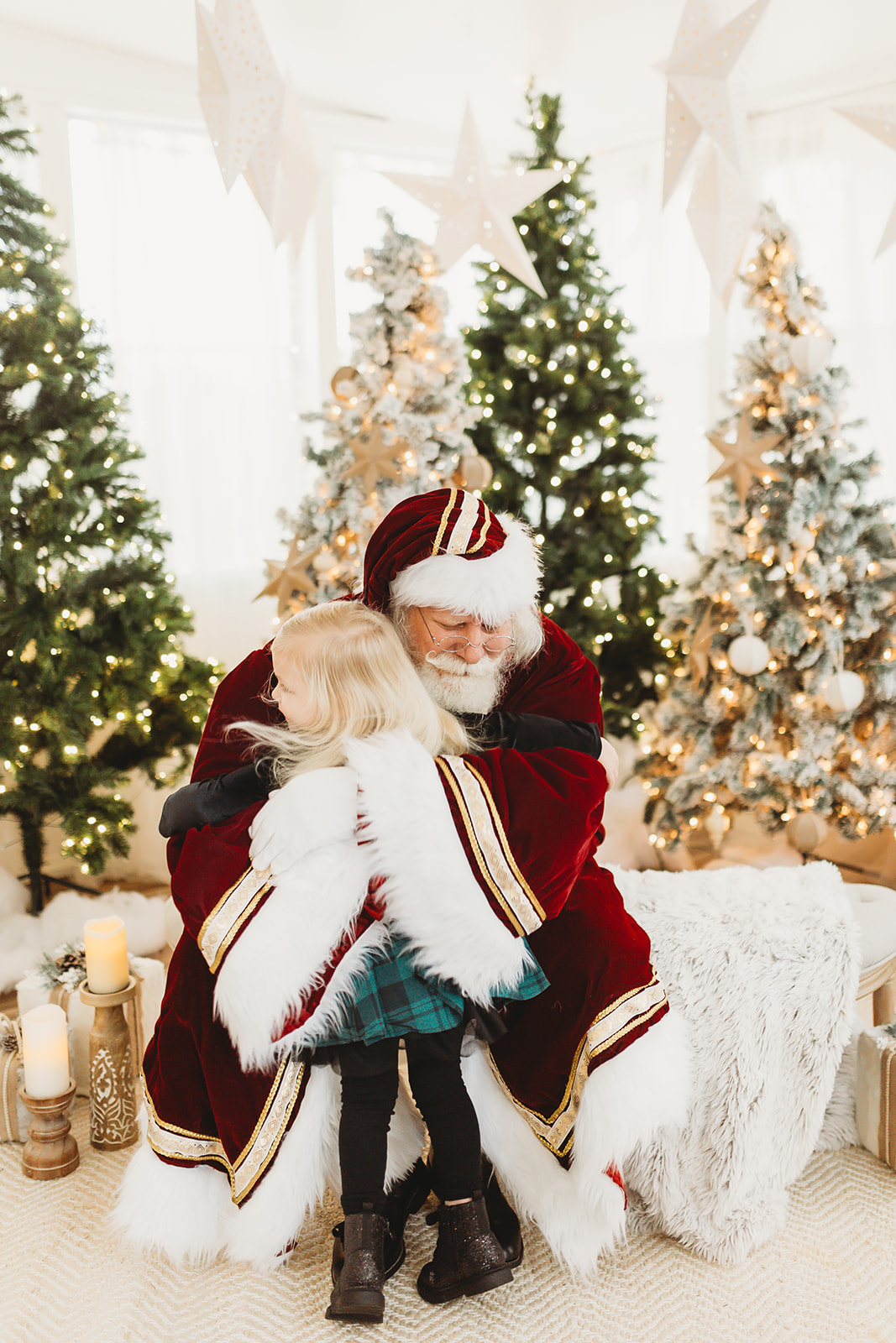 Santa Bob, the well-known Lenox Square Mall Santa, warmly embraces a young child during a holiday mini session in Lawrenceville, Georgia. Captured by Denay Shook Photography, Atlanta Santa photographer
