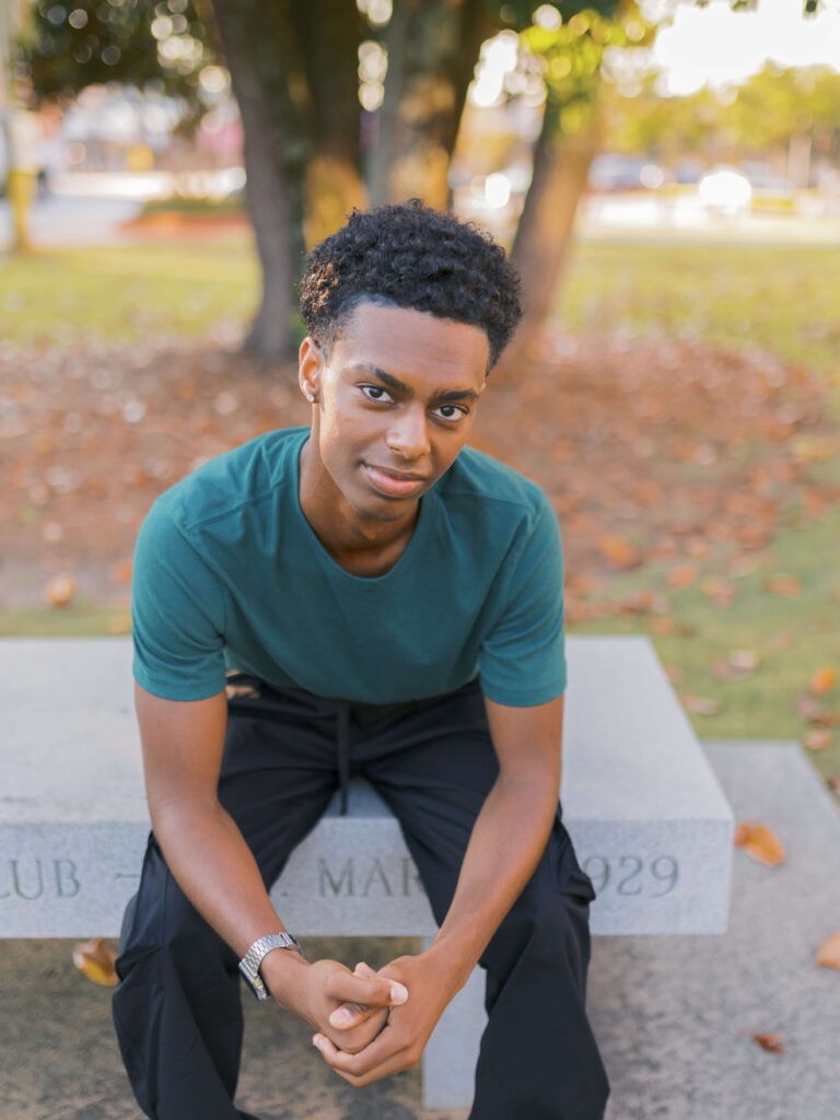 Graduation senior sits on a bench in downtown lawrenceville