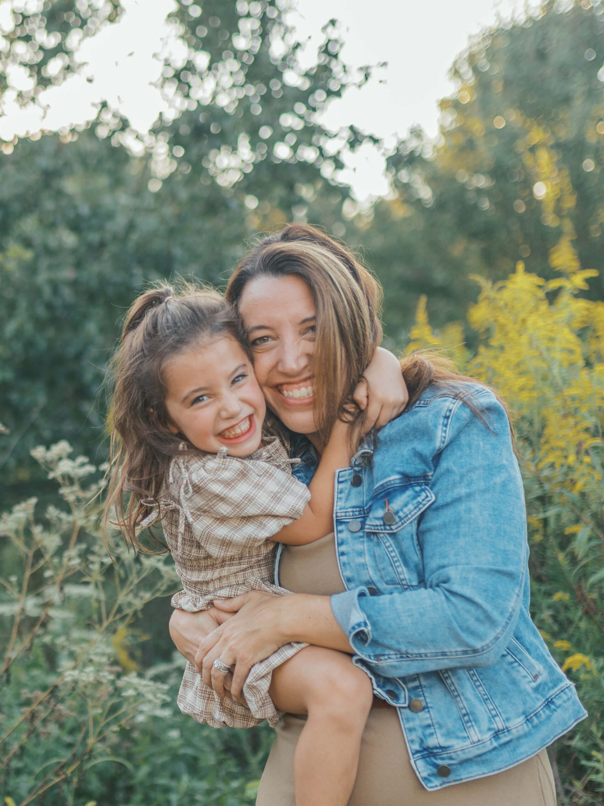 Mother and daughter smiling and hugging during a sunset family session at Garrard Landing Park in Alpharetta, Georgia.