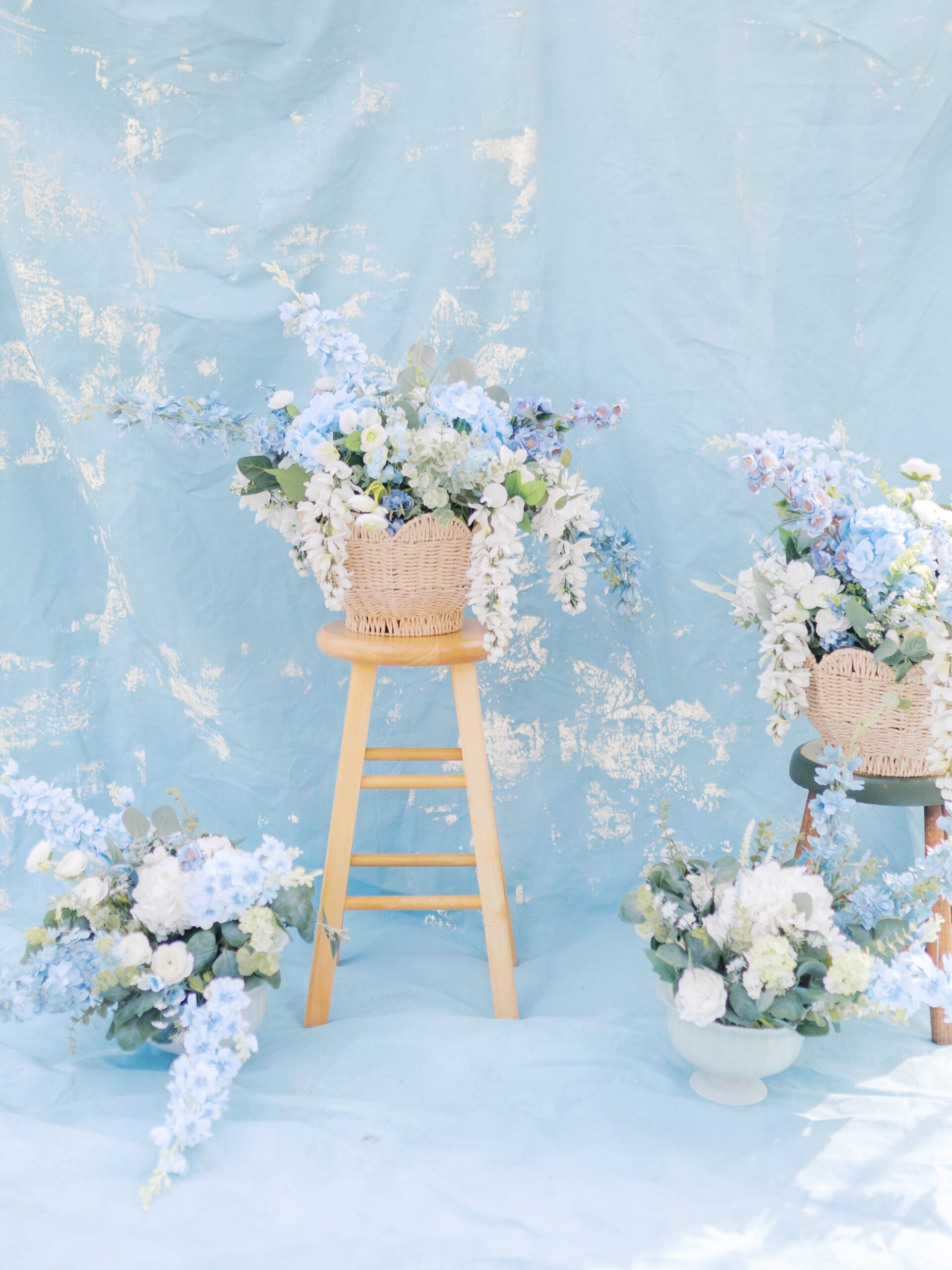 floral arrangemens up against. a blue cloth